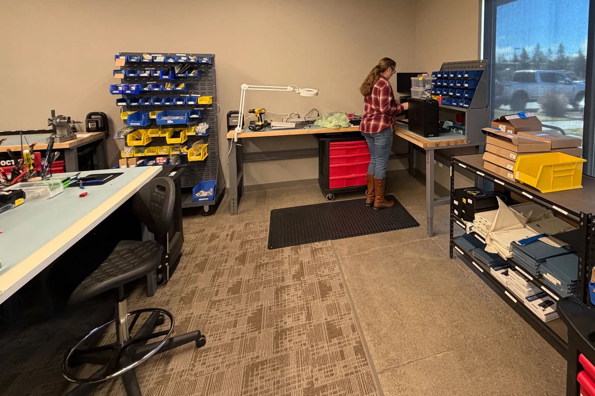 PMI assembly workstation with parts bins and tool cart at Bend facility